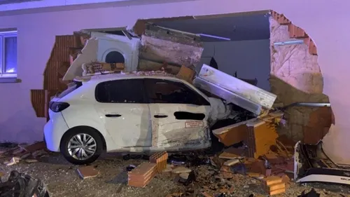 Une voiture projetée contre la façade d'une maison  