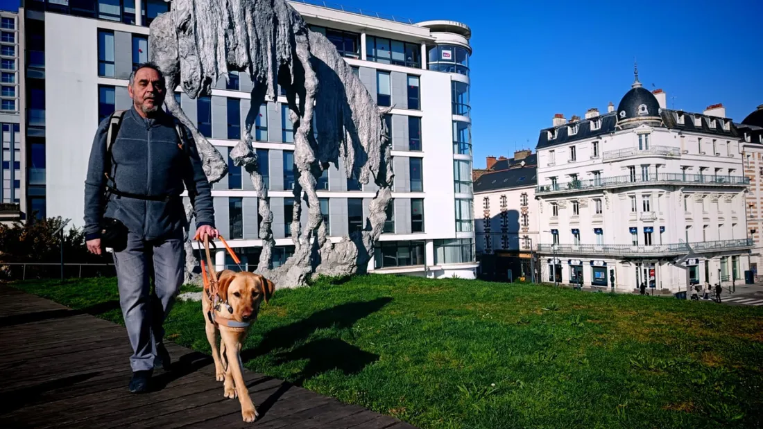 Personne malvoyante avec son chien guide.
