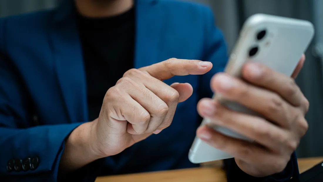 Un homme reçoit une alerte sur son téléphone portable. 