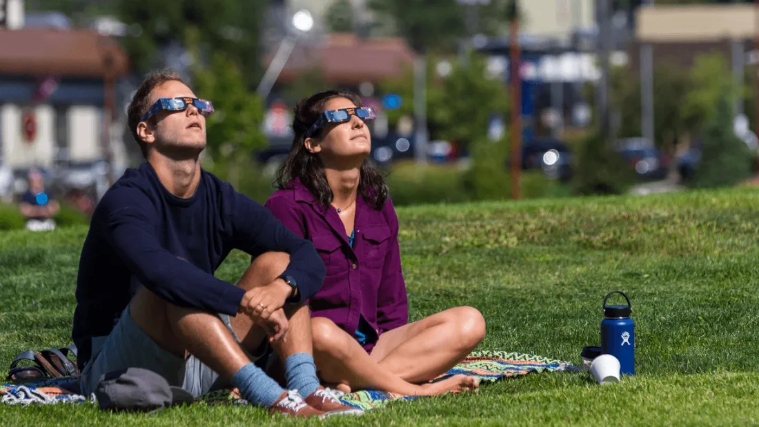Couple avec des lunettes en train de regarder une éclipse