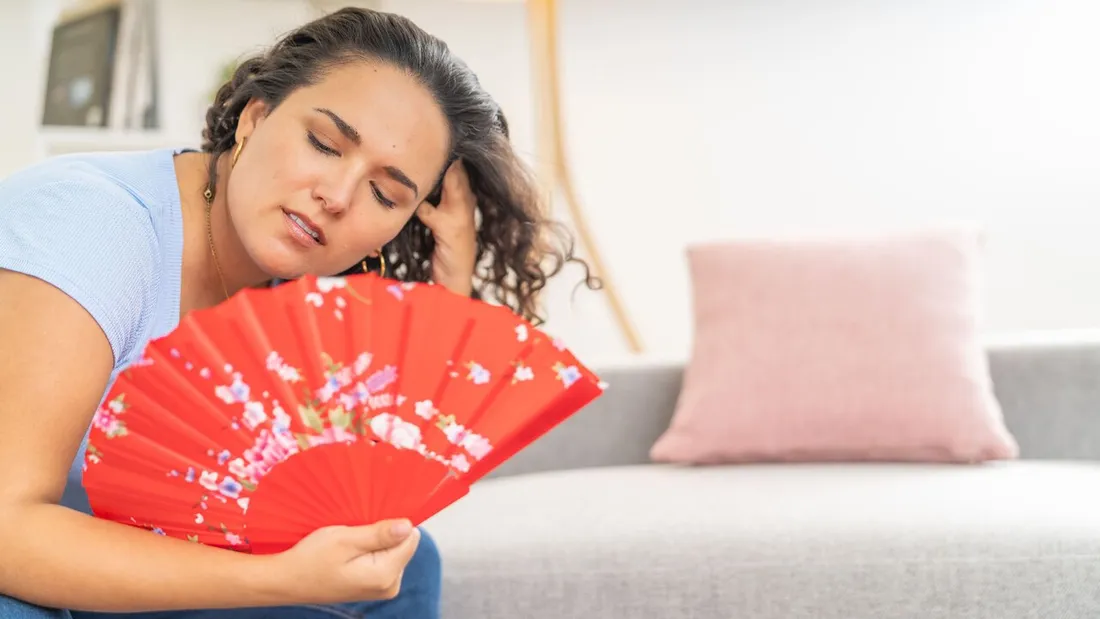 Femme se rafraichissant avec un éventail