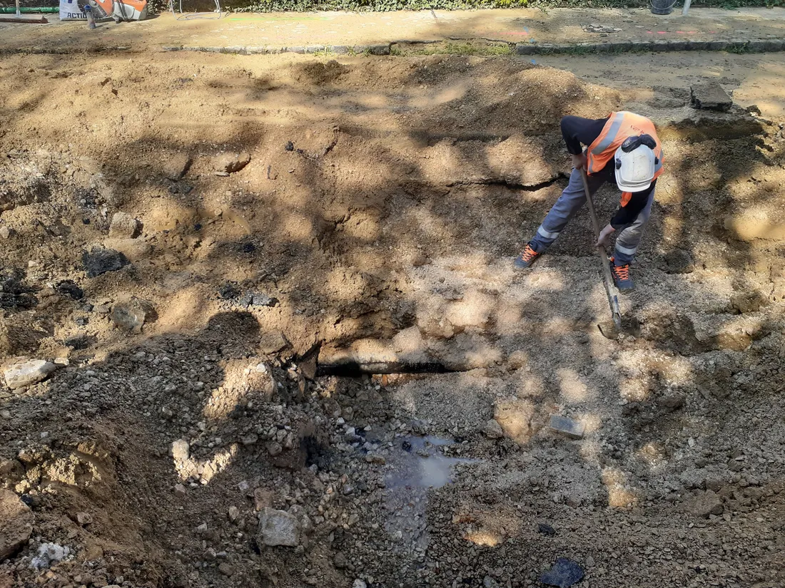 Ici, un ouvrier déblayant des gravas pour remettre le service d'eau en état 