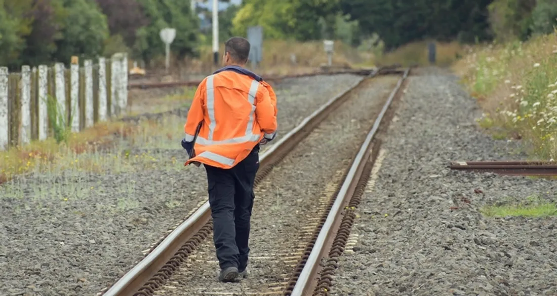 Ouvrier qui marche sur les rails