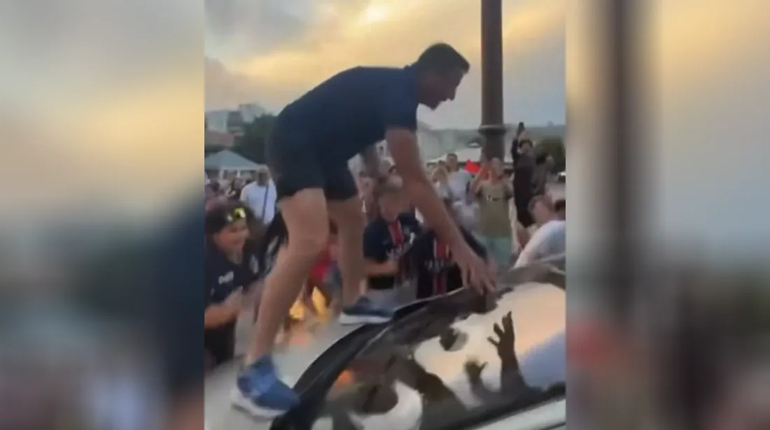 Karl Olive sur le capot d'une voiture