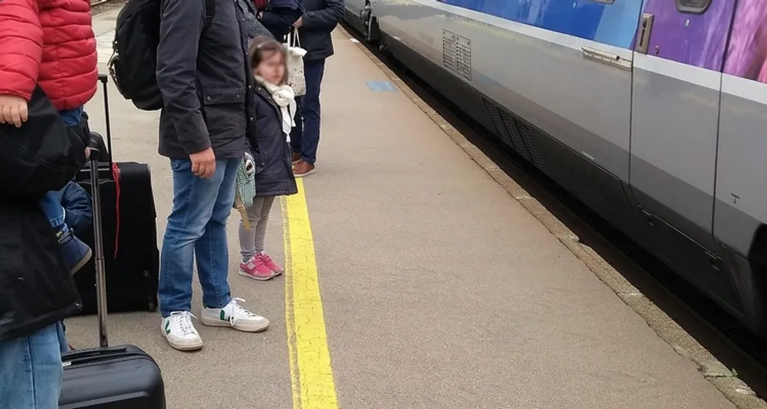 Voyageurs sur le quai d'une gare