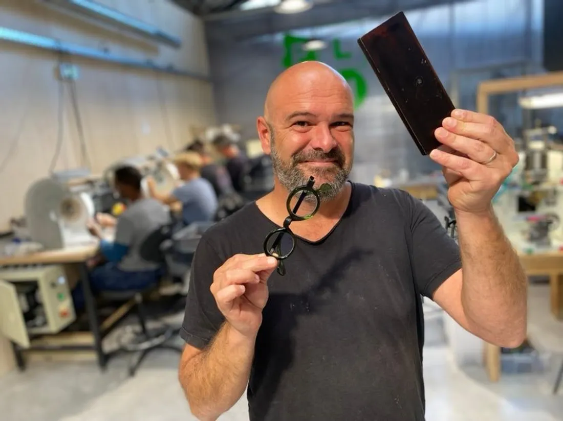Jean-Philippe Douis avec une paire de lunette et une plaque de matière recyclable