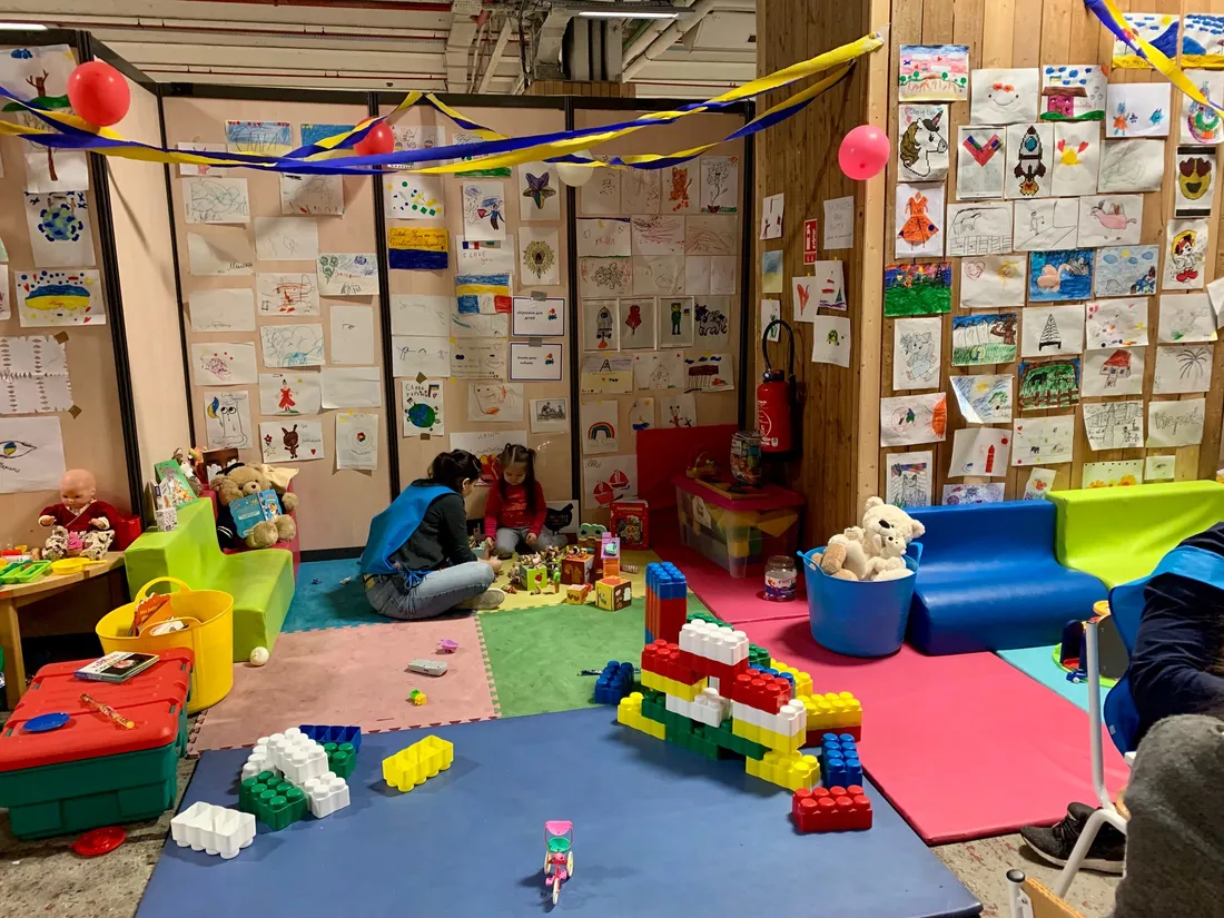 Une bénévole joue avec une petite fille ukrainienne dans le centre d'accueil des réfugiés.