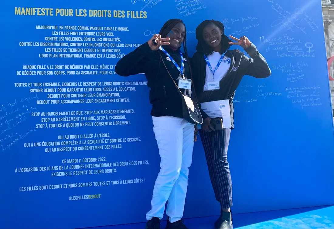 Dorcas (à droite) devant le plaidoyer signé par les personnalités présentes durant la manifestation.