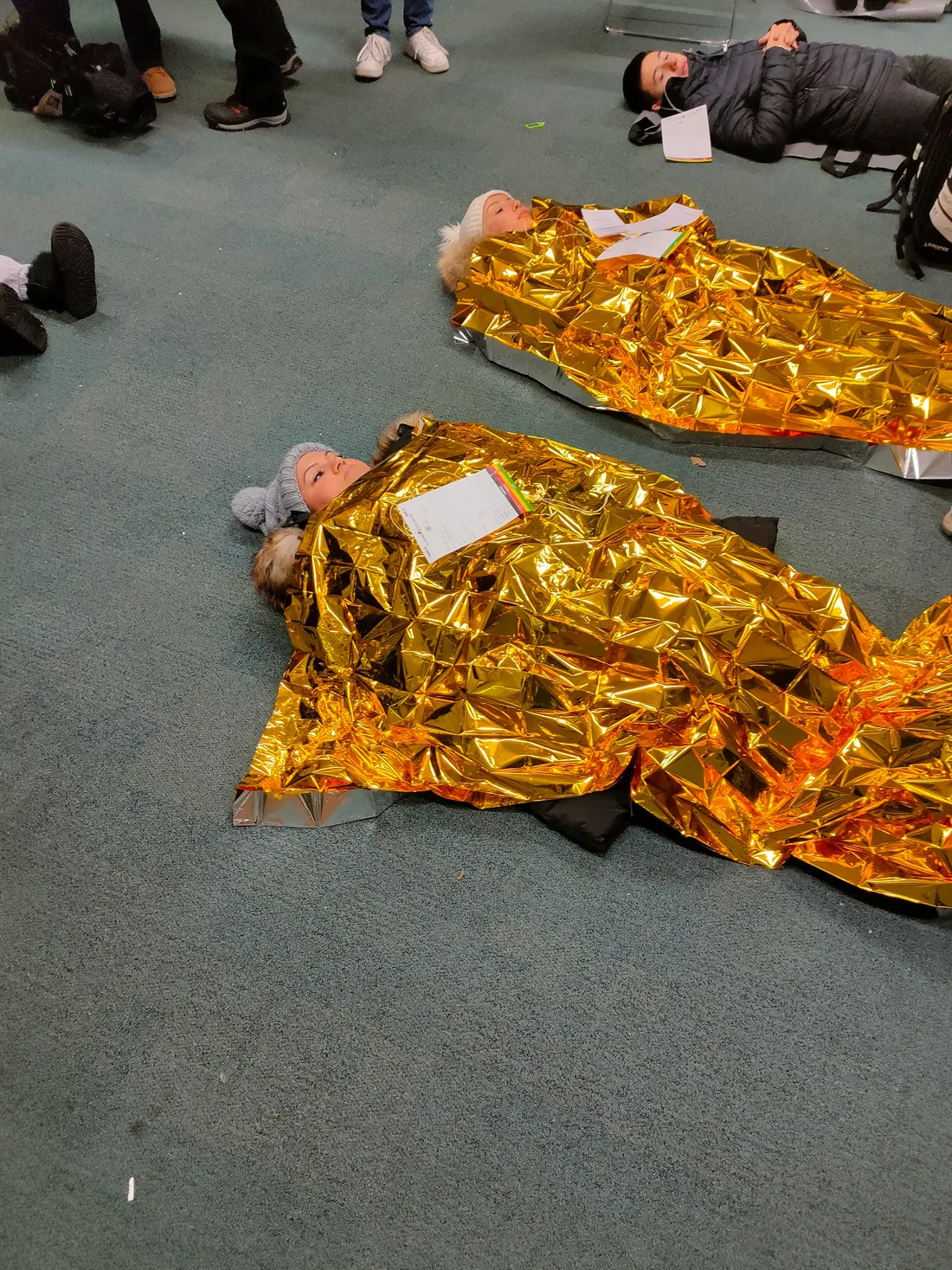 Après l'exercice certains participants "morts" ou "blessés" ont des couvertures de survie