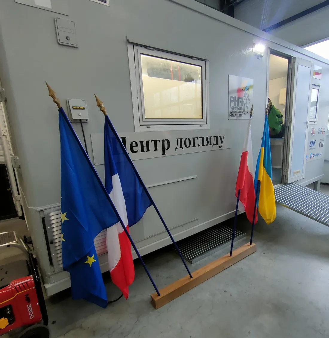 Les drapeaux de l'Union Européenne, français, Ukrainien et Polonais devant le conteneur des PHF