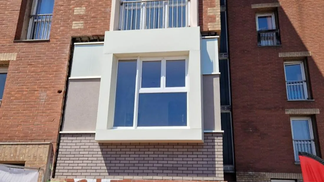 Trois matières sont utilisées : briques foncées, enduit et bardage en aluminium. 