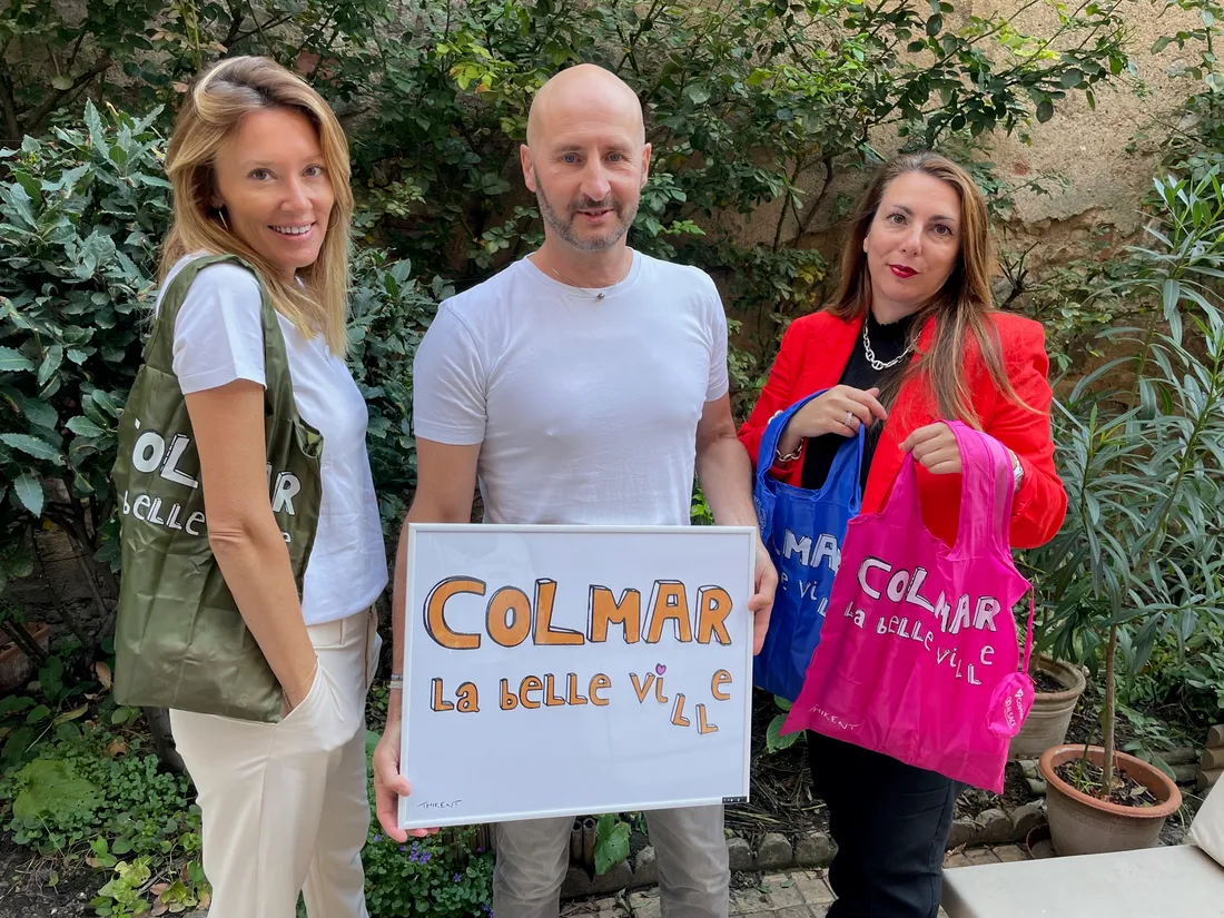 L'artiste Thikent (au centre) présente le sac avec l'équipe des Vitrines de Colmar
