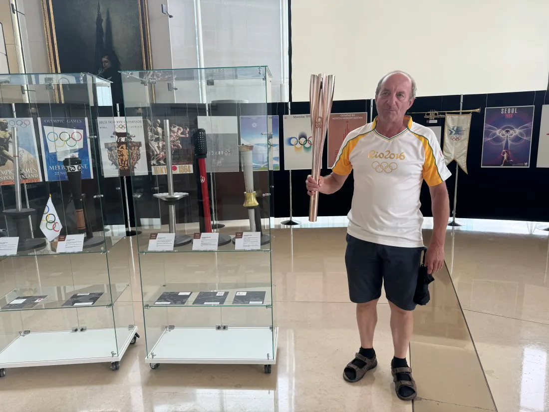 Pascal tient ici en mains la torche olympiques des Jeux Olympiques de Tokyo 