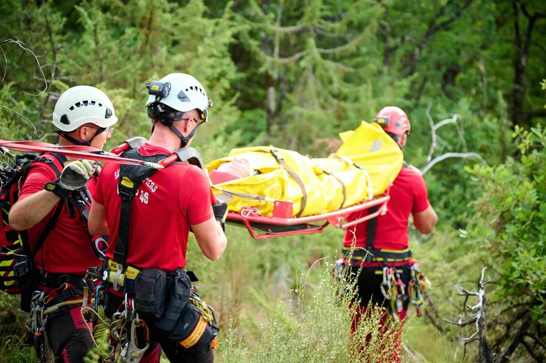 La victime évacuée en civière dans ce secteur boisé et difficile d'accès