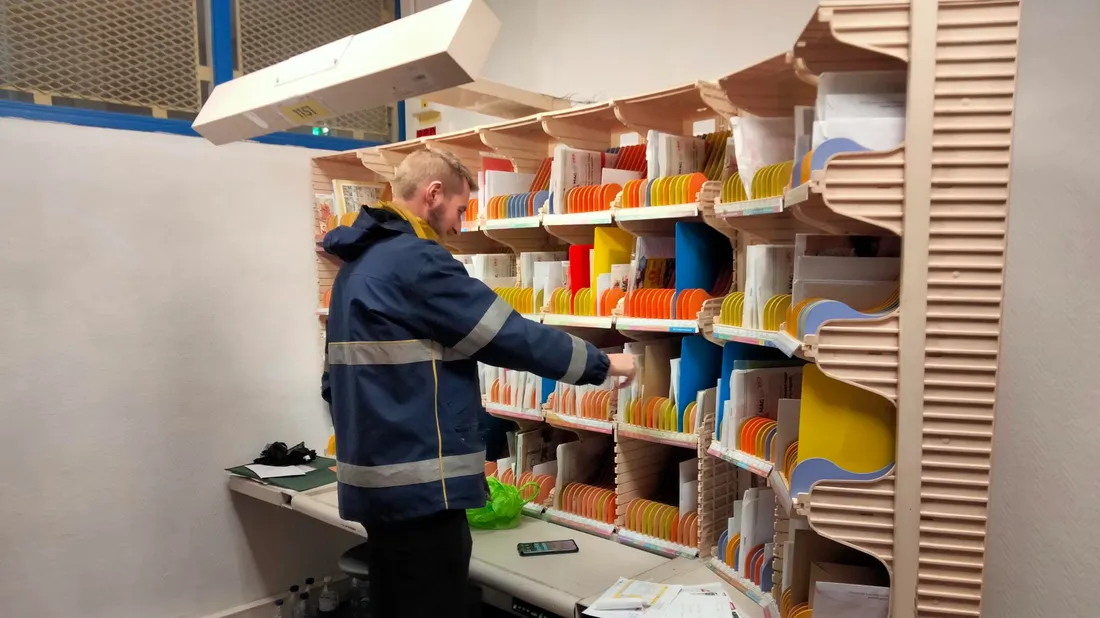 Un facteur en train de trier du courrier
