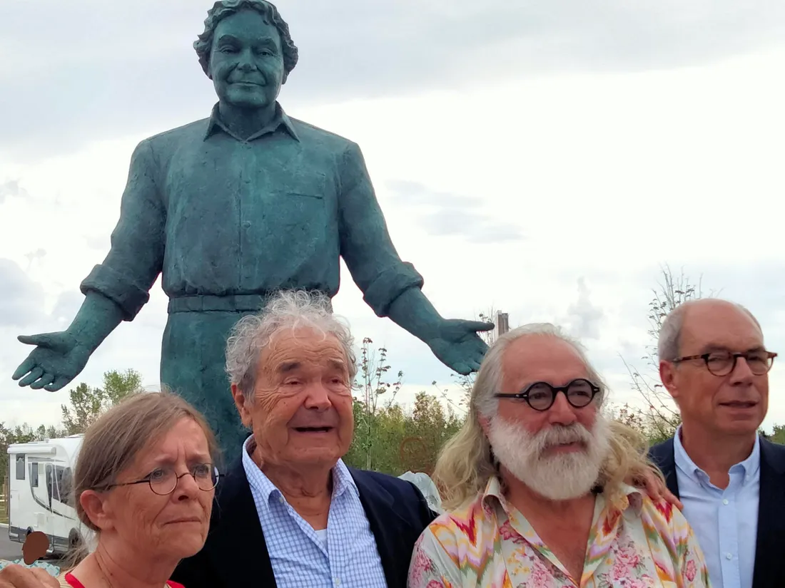 Pierre Perret devant une des statues à son effigie.