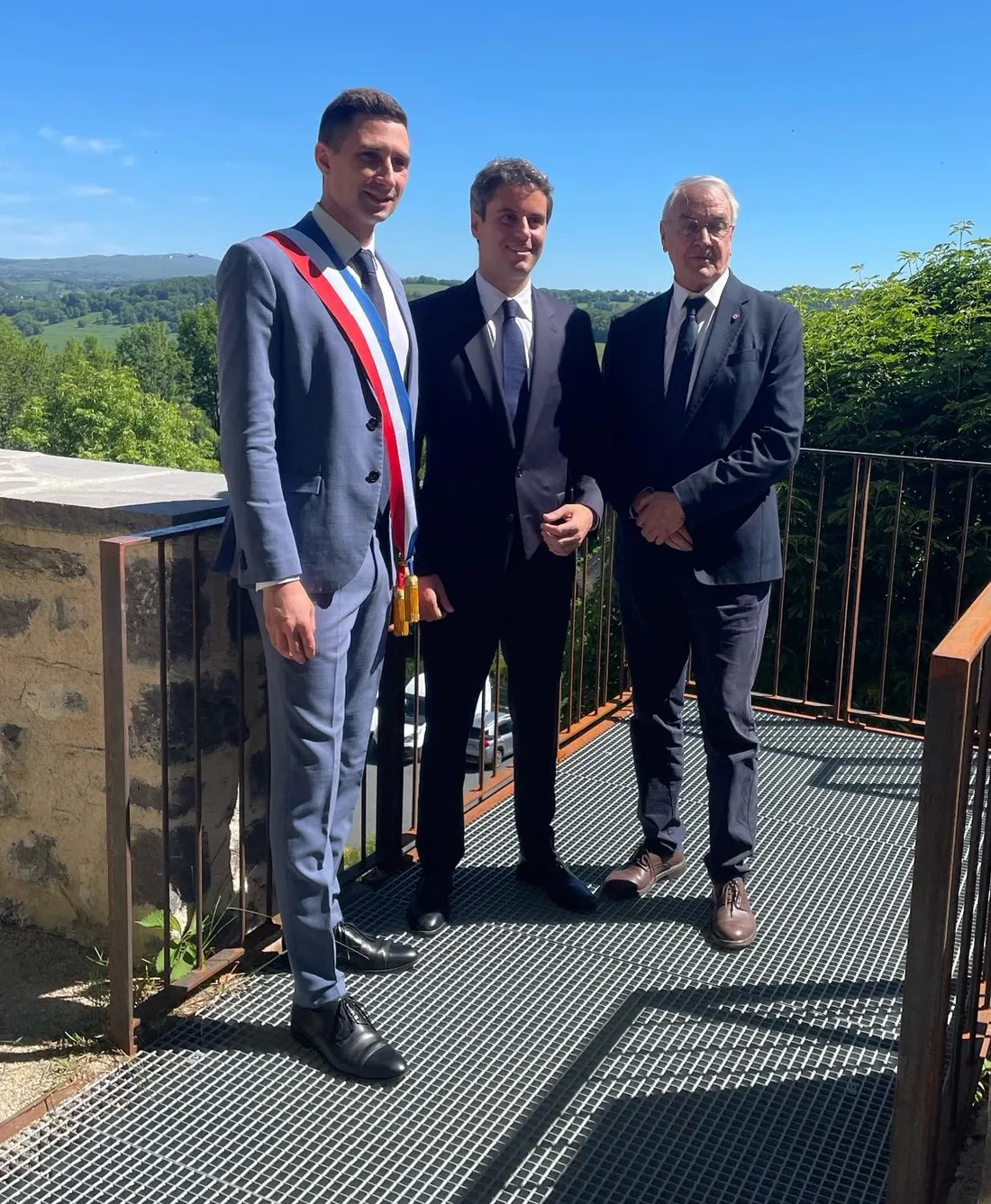 Gabriel Attal entouré du maire de Mur-de-Barrez et du député de l'Aveyron.