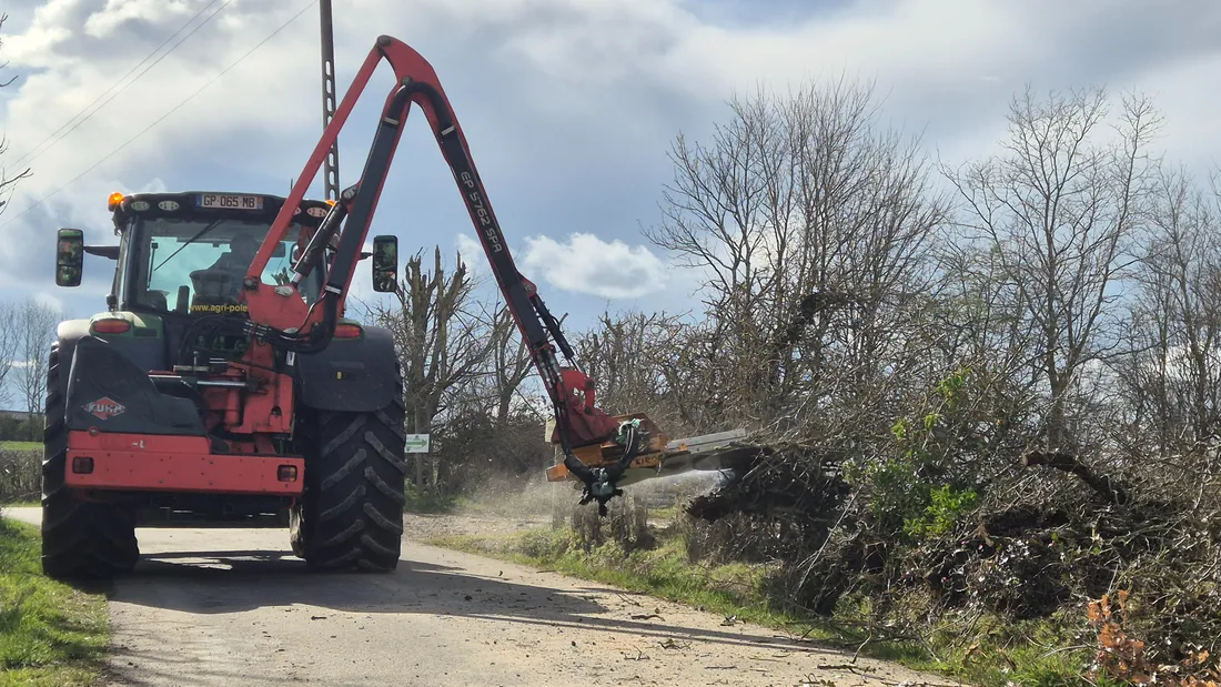 Un tracteur qui taille une haie à la scie. 