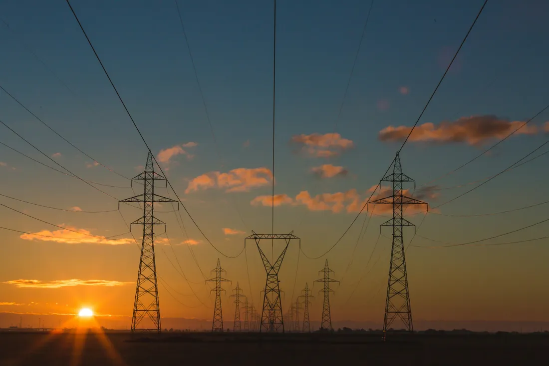 Pylônes et lignes à haute tension au coucher du soleil.
