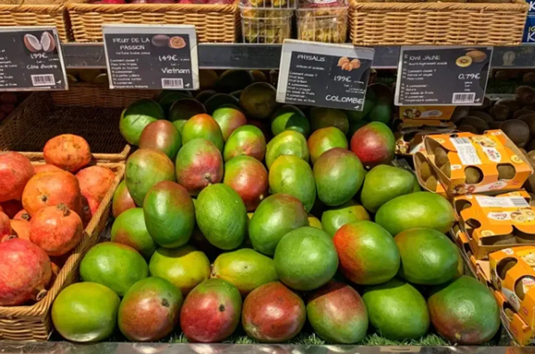 Des mangues sur l'étal du rayon fruits et légumes d'un supermarché en France.