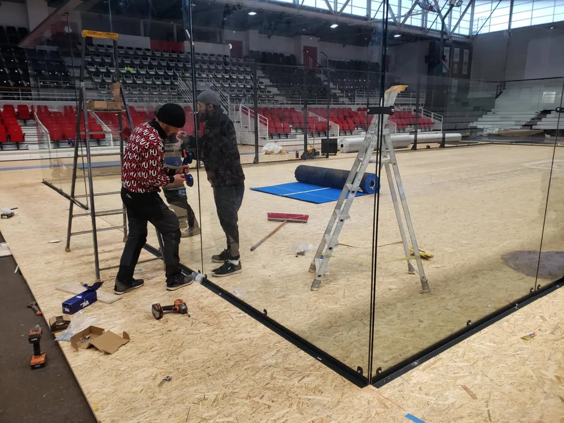 Des ouvriers en train d'installer le terrain de padel