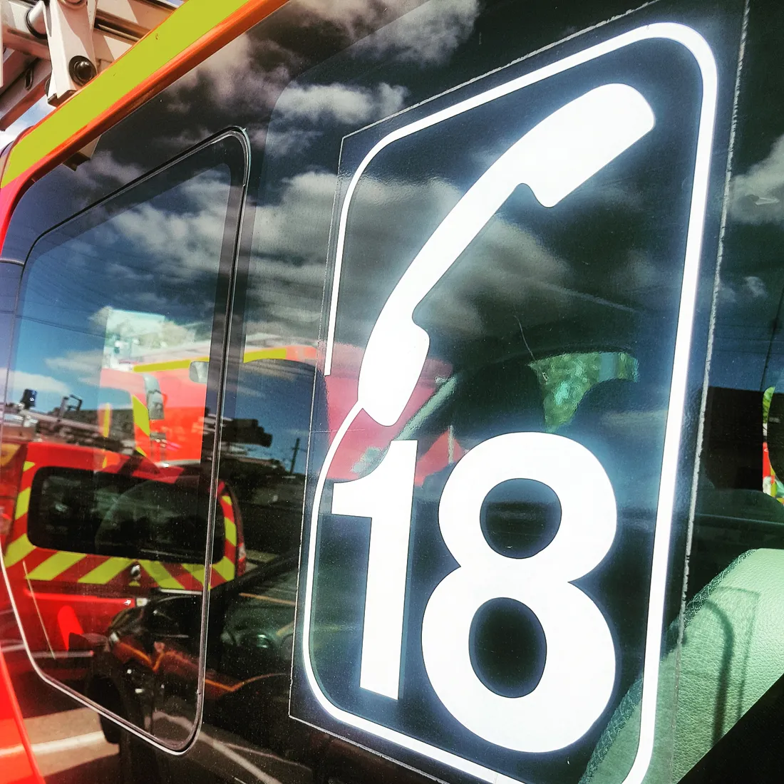 Vitre d'un camion de pompier avec l'affichage "téléphone" et "18"