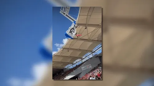 Le parachutiste se retrouve coincé sur le toit du stade, retardant...