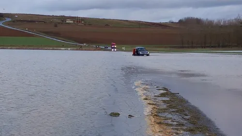 Une voiture immergée sur une route inondée