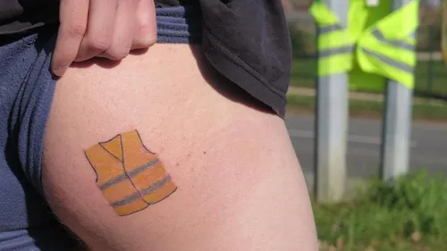 Il se fait tatouer un gilet jaune sur...la fesse