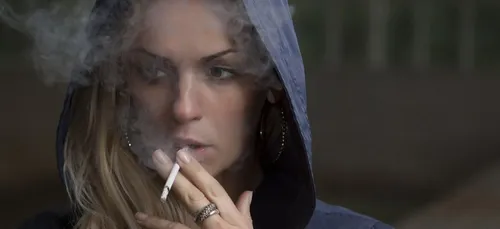 Elle allume une cigarette après avoir mis du déodorant et se brûle...