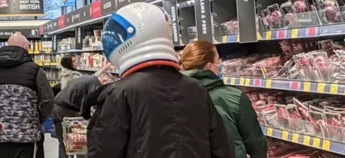 Un homme se balade avec un casque d’astronaute pour se protéger du...