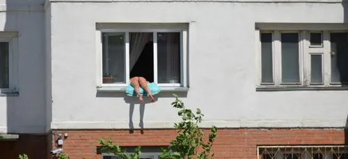 Elle bronze nue à sa fenêtre