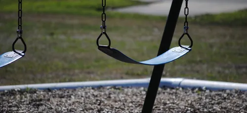 Des balançoires roses installées à la frontière entre les...