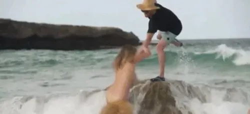 Topless, Kate Upton se prend une vague et se vautre en pleine mer....