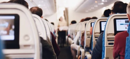 Une hôtesse de l'air saute d'un compartiment bagages pour amuser...