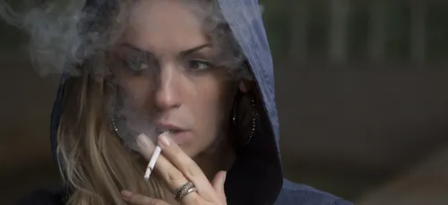 Elle allume une cigarette après avoir mis du déodorant et se brûle...