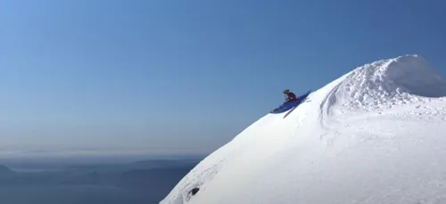Un homme fait du kayak sur une montagne enneigée (Vidéo)