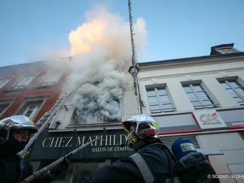 Une personne réfugiée sur un toit pour échapper à un incendie à...