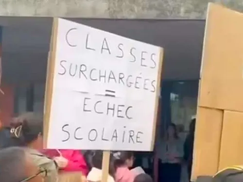 Des parents d'élèves devant les grilles de leur école pour...