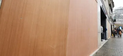 Il pose des panneaux sur une vitrine en oubliant la femme de ménage...