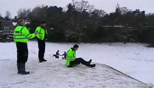 Des policiers utilisent leur bouclier antiémeute comme luge