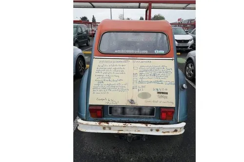 Il recopie l'attestion de sortie sur sa 2CV !